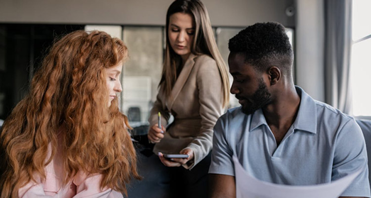 three young business people looking at a device