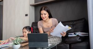 mom working at home with daughter beside her